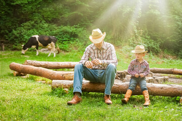 happy child with cowboy parent in nature in the field