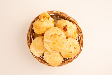 Brazilian cheese bread isolated inside a wooden basket in a white clean background in aerial top view