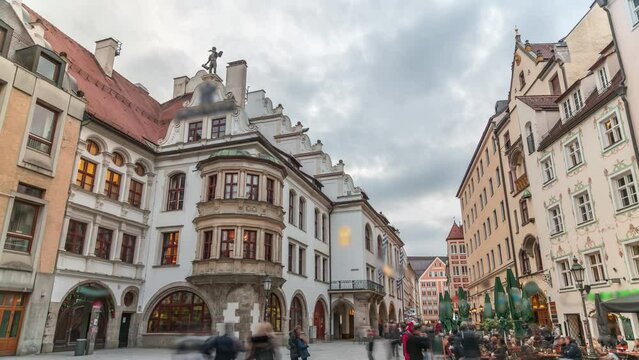 Cityscape with bier houses and restaurants outdoors on Platzl timelapse in Munich, Bayern, Germany. Walking area with tables and chairs. People relaxing in cafes