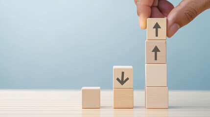 Hand holding wooden blocks on an isolated background. Up and down arrows. Business concept for success and growth.