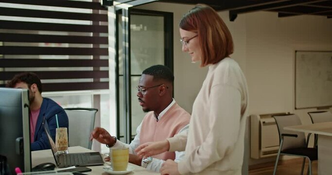 Colleagues from diverse backgrounds come together for a coffee break in a modern office, fostering camaraderie and relaxation in the dynamic workplace.