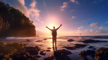 Foto op Plexiglas tourist on the coast looks at the sunset with his arms raised. trekking and nature walks © photosaint