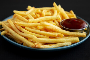 Homemade French Fries with Ketchup on a Plate, side view. Close-up.