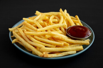Homemade French Fries with Ketchup on a Plate, side view. Close-up.