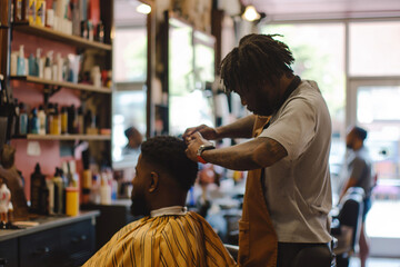 Young African American man receiving a stylish haircut at a barber shop, reflecting a modern grooming experience.

