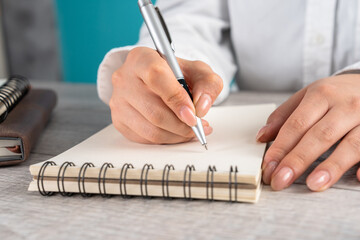 Woman making notes in notepad, business concept
