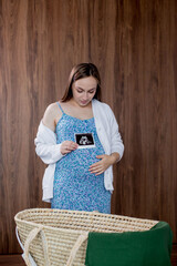 A pregnant woman looks at the ultrasound photo of her baby