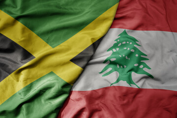 big waving national colorful flag of lebanon and national flag of jamaica .