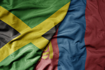 big waving national colorful flag of mongolia and national flag of jamaica .