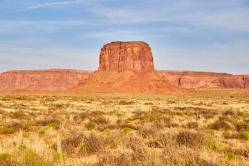 Monument Valley Butte with Desert Flora under Blue Sky