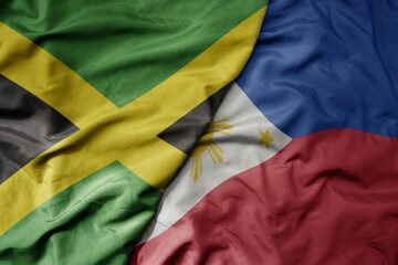 big waving national colorful flag of philippines and national flag of jamaica .