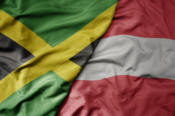big waving national colorful flag of austria and national flag of jamaica .
