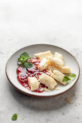 Lazy dumplings, vareniki with raspberry jam decorated with almond petals and mint leaves isolated. Boiled cottage cheese homemade gnocchi