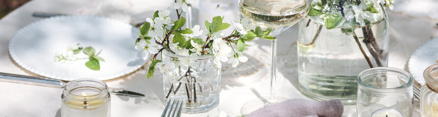 Rustic elegant eco friendly zero waste trendy wedding reception table decor with fresh spring apple cherry flowers in bloom. Beautiful marriage decoration, holiday outdoors in the family garden banner