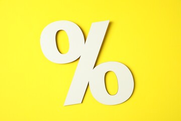 White percent sign on yellow background, top view