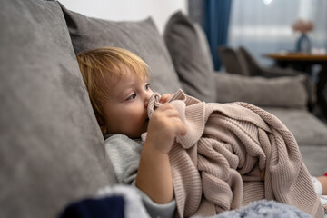 Little baby girl laying on a couch with her blanket, ready to sleep