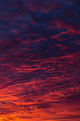 Epic dramatic bright sunrise, sunset orange red clouds on sun in sunlight on dark blue sky...