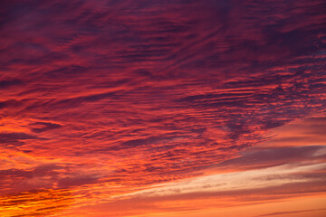 Epic Dramatic sunrise, sunset red orange sky with cirrus clouds in sunlight abstract background texture