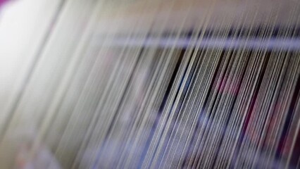 View of silk thread lined up in traditional silkworm spinning machine. - Powered by Adobe