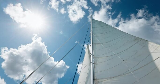 Travel with sailing catamaran yacht boat, perspective view of open white sails mainsail, spinnaker sun rays and sky clouds video
