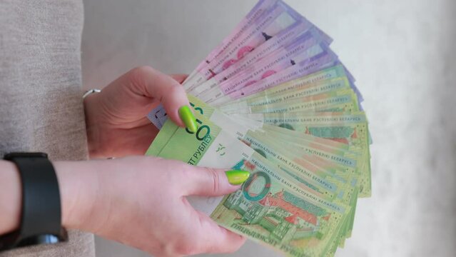 Female hands holding paper bills Belarusian rubles 