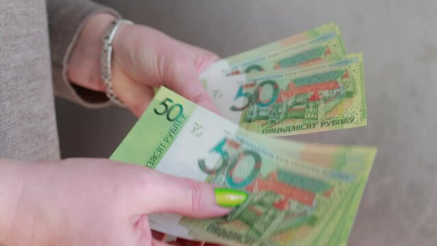 Female hands holding paper bills Belarusian rubles 