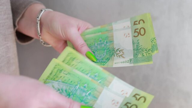 Female hands holding paper bills Belarusian rubles 