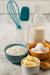 Ingredients to prepare cake. Wheat flour, eggs, butter and milk.