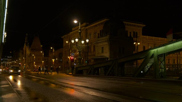 Busy public transportation in Budapest bridge. A night cityscape with busy cars on the bridge against night sky.