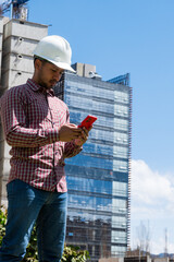 construction worker on site looking his phone in sunny day