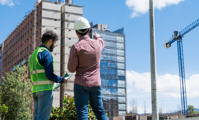 Workers at work looking some documents for a deal in construction site