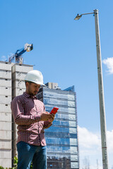 construction worker on site looking his phone in sunny day