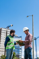 Workers at work looking some documents for a deal in construction site