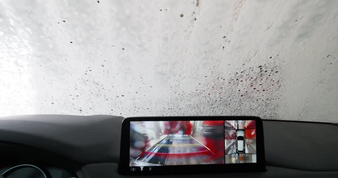 View from inside a car in an auto wash with water on windshield
