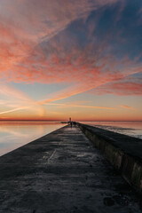sunset in the sea and a long jetty