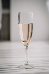 Valmiera, Latvia - July 7, 2023 - Champagne glass with wedding rings inside, on striped surface.