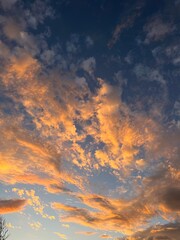 Cloudscape of orange and grey at dusk lit from beneath.