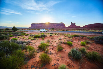 Desert Road Trip at Sunrise in Monument Valley, White Car Parked