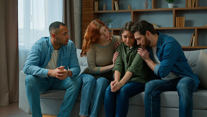 Desperate sad woman cry complain life problem diverse women and men colleagues buddies support stressed girl multiracial team sit on psychological therapy group meeting at home give help calm friend