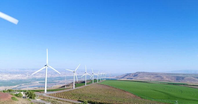 Aerial footage of a wind turbine in the mountains above the Sea of Galilee.
