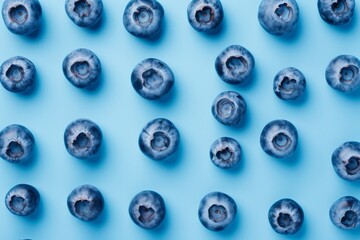 A vibrant cluster of plump, ripe blueberries stand out against a rich blue backdrop, evoking feelings of freshness and sweetness in this delectable image of juicy fruit