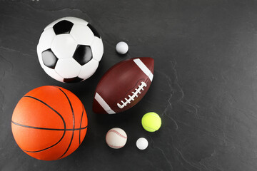 Many different sports balls on dark gray background, flat lay. Space for text