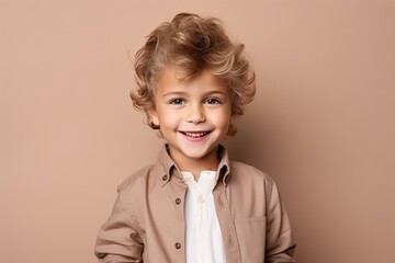 Portrait of a cute smiling little boy with blond curly hair.