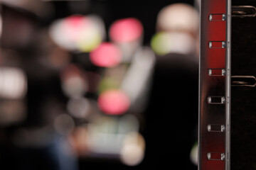 Selective focus of dark room equipped with metallic storage full with federal documents. In background private detectives working overhours at criminal case, analyzing crime scene evidence