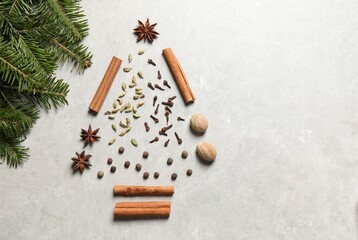 Christmas tree made of different spices and fir branches on light gray textured table, flat lay. Space for text