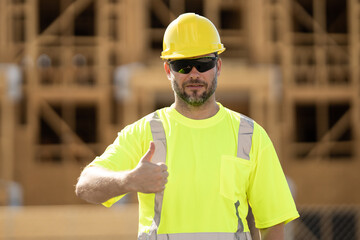 Worker man on the building construction. Construction site worker in helmet work outdoors. Builder worker working on construction site. Construction site worker outdoor portrait.