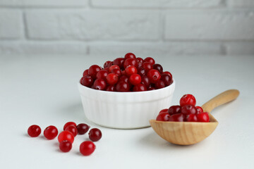 Cranberries in bowl and spoon on white table