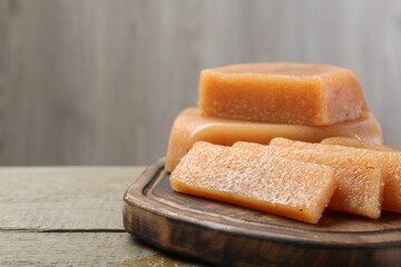 Tasty sweet quince paste on wooden table, closeup. Space for text