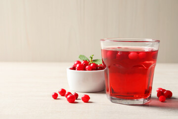 Tasty refreshing cranberry juice and fresh berries on light wooden table. Space for text