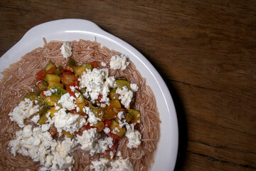 Traditional Mexican food of noodle soup with Cucurbita pepo Cocozzelle, cheese and tomato